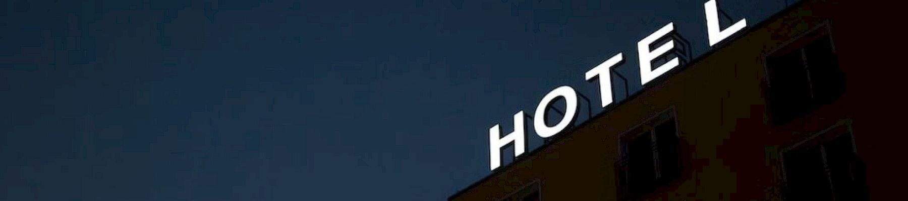 A building with a "HOTEL" sign is visible against a dark sky, with the "L" slightly detached.
